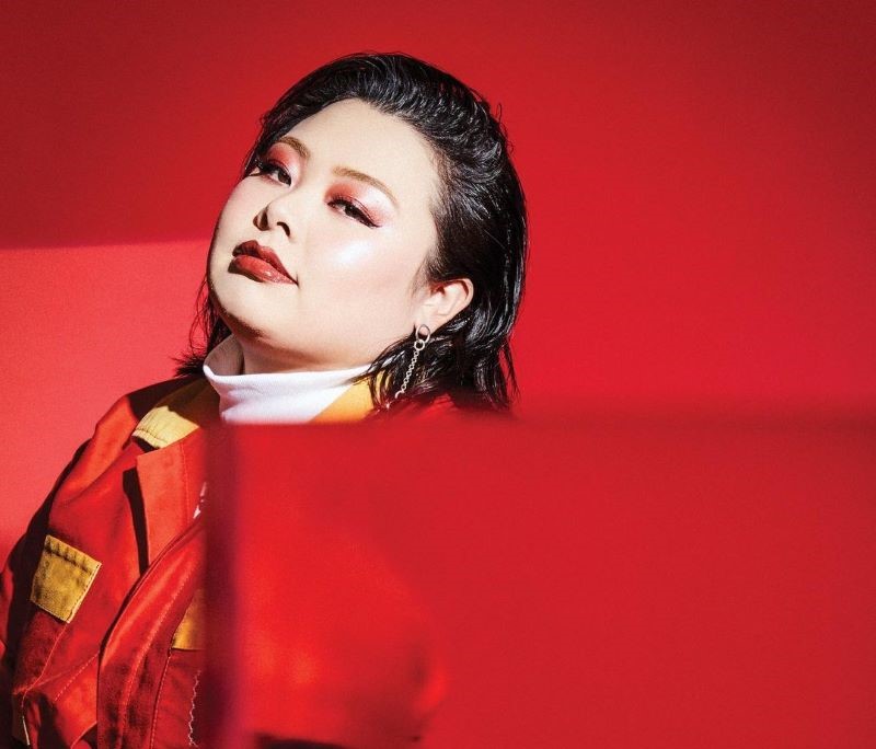 真っ赤な衣装と背景の渡辺直美さんの写真